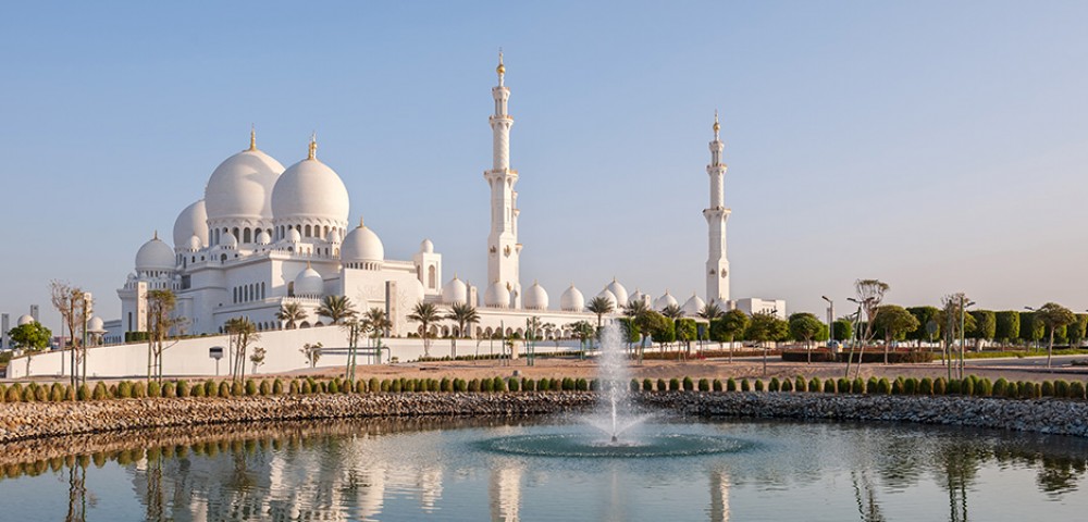 Abu Dhabi City Tour Combo beautiful skyline next to beach and group of people walking to Louvre Museum Abu Dhabi 