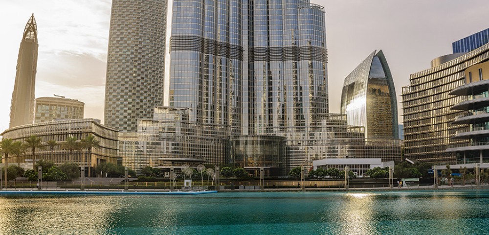 Dubai Sightseeing City Tour, a woman pointing to Burj Khalifa and Cruise Combo Deals Creek at night