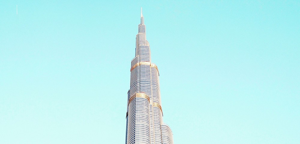 Dubai Sightseeing City Tour, a woman pointing to Burj Khalifa and Cruise Combo Deals Creek at night