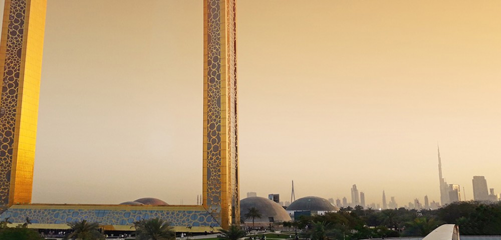 Dubai Sightseeing City Tour Combo Dubai Frame at day light and IMG Worlds of Adventure roaring dinosaur at night