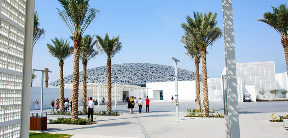 Abu Dhabi City Tour Combo beautiful skyline next to beach and group of people walking to Louvre Museum Abu Dhabi 