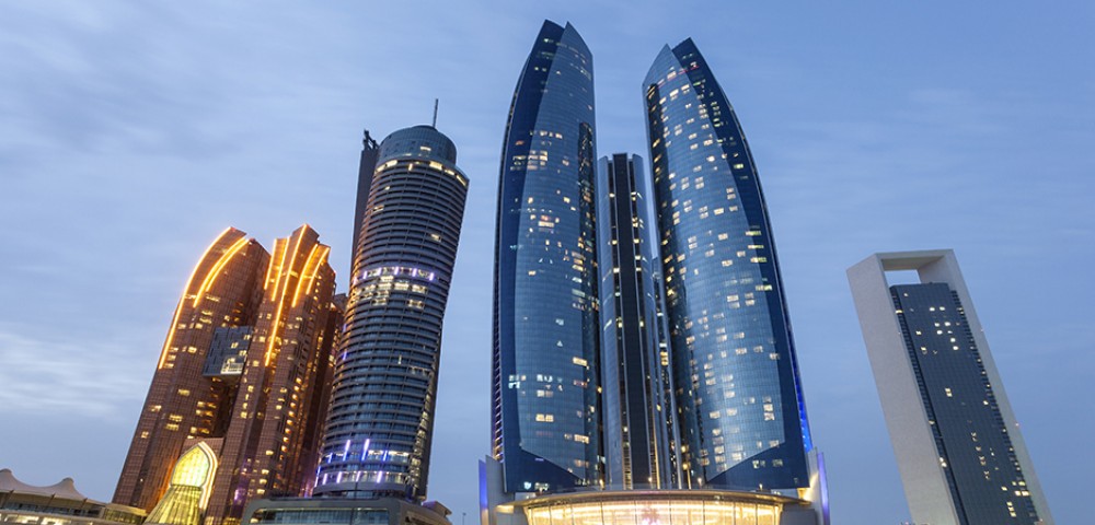 “A desert safari combo with a vehicle driving on the desert and Abu Dhabi City Tour combo  with tall buildings in the background”