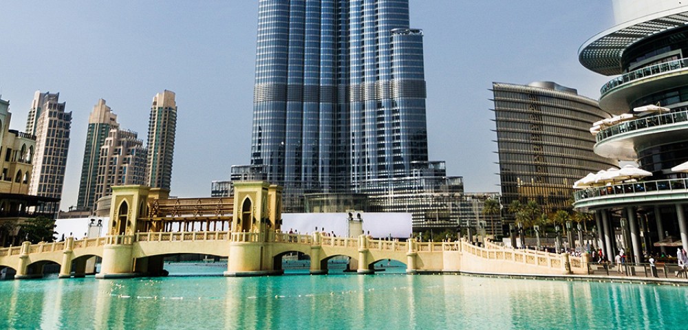 Dubai Sightseeing City Tour, a woman pointing to Burj Khalifa and Cruise Combo Deals Creek at night