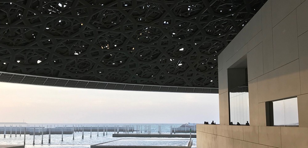 Abu Dhabi City Tour Combo beautiful skyline next to beach and group of people walking to Louvre Museum Abu Dhabi 