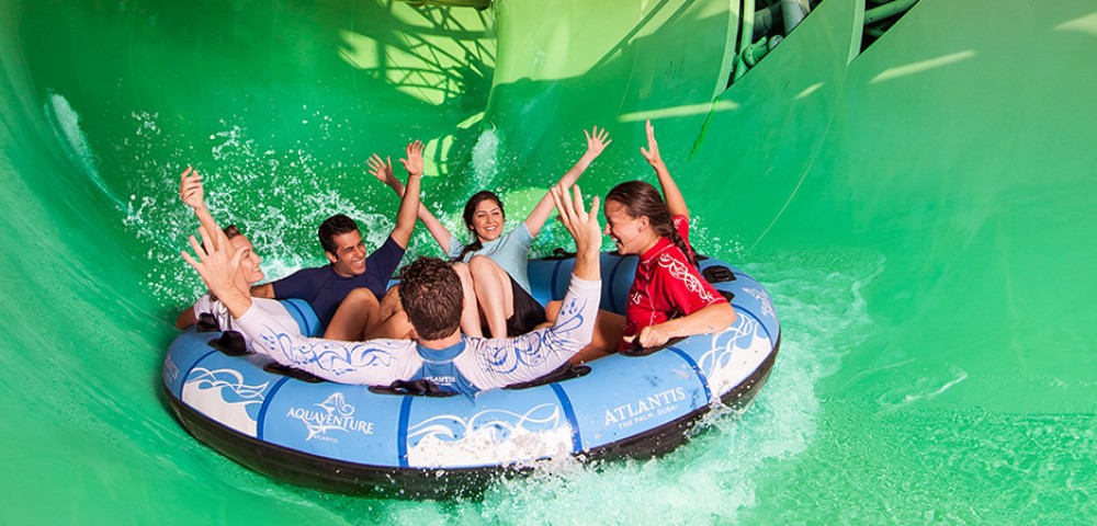 Abu Dhabi high rise buildings on the background of blue sky and Yas Water World on the background of amber sky