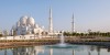 Abu Dhabi City Tour Combo beautiful skyline next to beach and group of people walking to Louvre Museum Abu Dhabi 