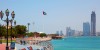 Abu Dhabi high rise buildings on the background of blue sky and Yas Water World on the background of amber sky