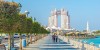 Abu Dhabi high rise buildings on the background of blue sky and Yas Water World on the background of amber sky